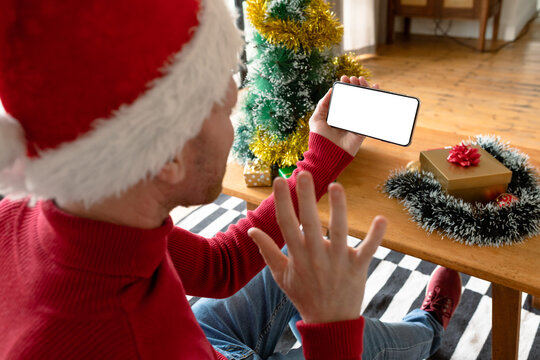 Albino african american man wearing santa hat making video call on smarphone with copy space