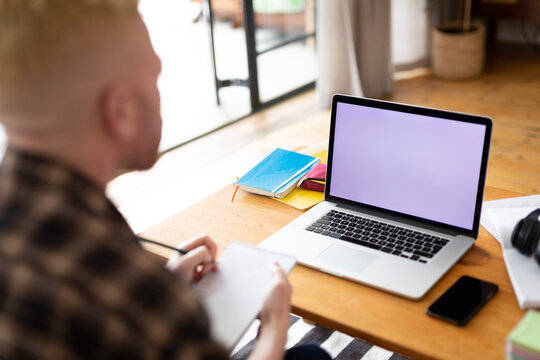 Albino african american man working from home using laptop with copy space - Powered by Adobe