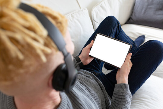 Albino african american man in the living room using tablet with copy space - Powered by Adobe