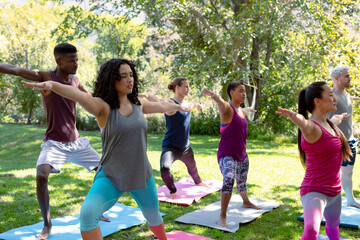 Group of diverse female and male people practicing yoga outdoors - Powered by Adobe