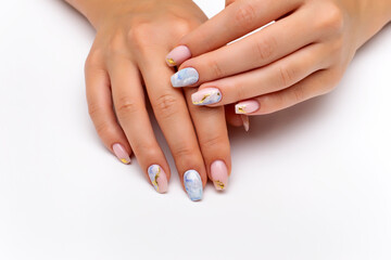 Nude, natural manicure with blue, white streaks and gold foil on long square nails. Gel nails. Heavenly manicure. Close-up on a white background.