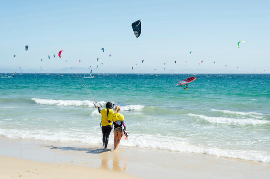 Female instructor giving kiteboard training to woman at beach