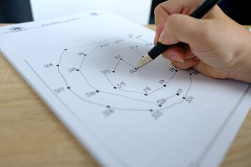 close-up female hand draws lines on paper, connects dots by numbers, concept of brain development in old age, preventive measures in the fight against senile dementia, therapeutic health support