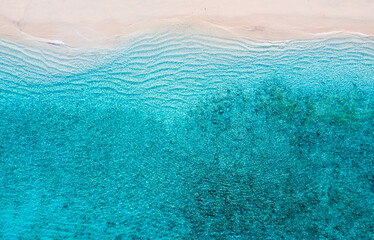 Fototapeta na wymiar Beach and ocean as a background from top view. Azure water background from top view. Summer seascape from air. Travel and vacation image
