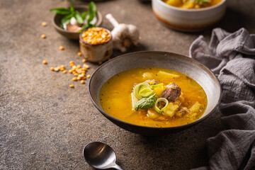 Closeup of a bowl of split pea soup with chunks of ham and meat