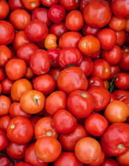 Fototapeta na wymiar A large pile of ripe red tomatoes, but not quite fresh, is on the counter.