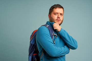 portrait of man backpacker over blue