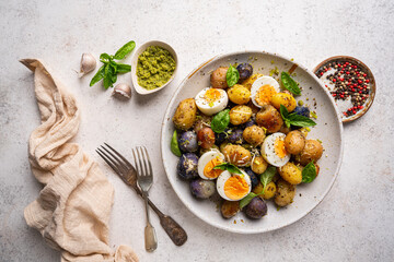 Homemade salad of new colorful potatoes, quail eggs and pesto, top view