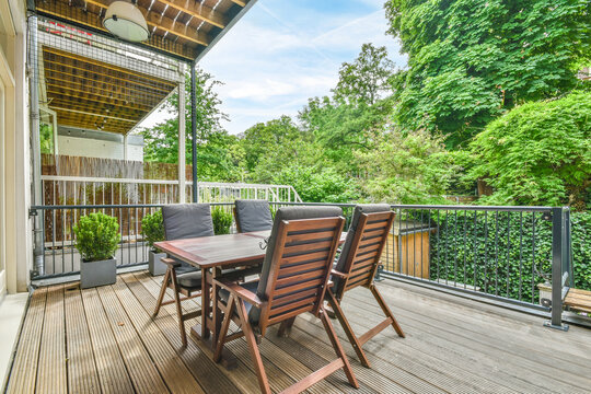 Table and armchairs on wooden terrace
