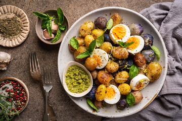 Homemade salad of new colorful potatoes, quail eggs and pesto, top view