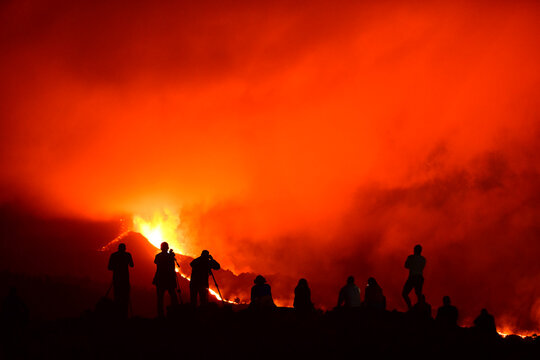 Human silhouettes recording, photographing and observing the exploding lava in La Palma Canary Islands 2021
