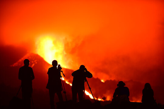 Human silhouettes recording, photographing and observing the exploding lava in La Palma Canary Islands 2021