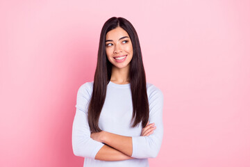 Fototapeta premium Photo portrait of girl with crossed hands in blue shirt smiling happy looking empty space isolated on pastel pink color background