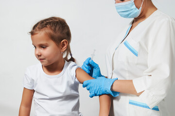 Female doctor injecting vaccine to girl