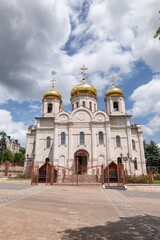 Fototapeta na wymiar Large Orthodox church with white-stone facade and gilded domes