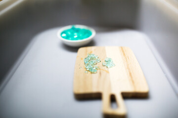 A child plays in the Sensory box with a hydrogel, children's hands touch, crush with a crush with blue water beads, Sensory development and Montessori, thematic activities with children