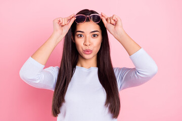 Portrait of attractive amazed girl touching specs news reaction pout lips oops isolated over pink pastel color background