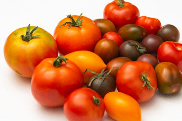 Red, yellow and black tomatoes on a white background. Set of multi-colored tomatoes