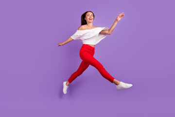 Fototapeta na wymiar Photo of glad dreamy sporty lady jump run enjoy flight wear white blouse isolated purple color background