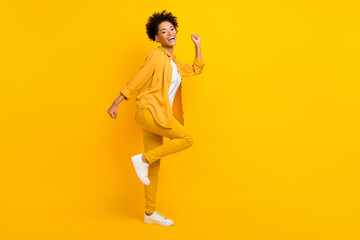 Full length body size photo woman wearing yellow clothes gesturing like winner isolated bright yellow color background
