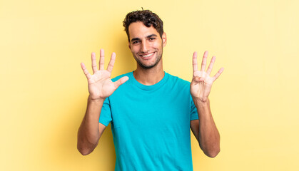 hispanic handsome man smiling and looking friendly, showing number nine