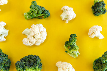 Vegetables, broccoli and cauliflower on yellow background.