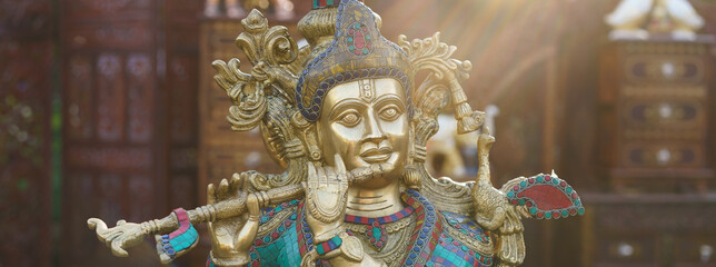 Panoramic photography of Hindu God Krishna. Statuette of Krishna playing the flute. Religious theme