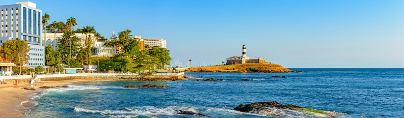 Fototapeta na wymiar Panoramic image during the afternoon of the Barra lighthouse, beach and buildings in the city of Salvador in Bahia