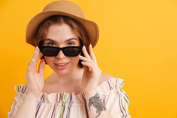 Young ginger woman in sunglasses looking at camera