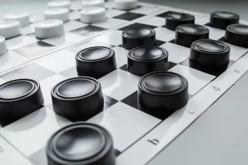 Foto op Canvas Chess board with checkers. Hobby. checkers on the playing field. Board games. Black and white checkers. © Anna