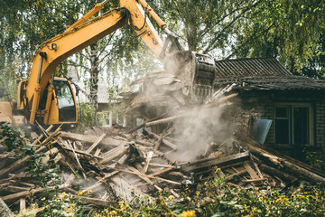 Demolition of old house. Excavator breaks building. City development, construction of new housing...