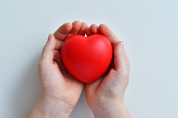 Red heart in woman's hands.red heart as a symbol of care and love