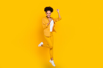 Full size profile side photo of young excited afro girl jumper rejoice victory isolated over yellow color background
