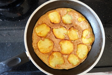 Sliced Spanish potato omelette in pan, selective focus. Potato Egg and Onion Omelette known locally as an Spanish Tortilla. It is called 