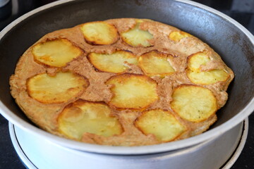 Sliced Spanish potato omelette in pan, selective focus. Potato Egg and Onion Omelette known locally as an Spanish Tortilla. It is called 