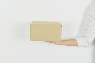 Woman hand holding cardboard box on white background with copy space.