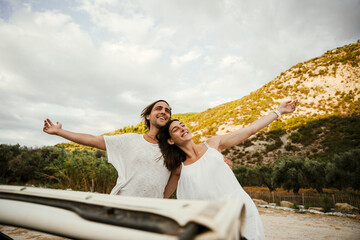 Caucasian romantic couple standing by mountain during sunset 