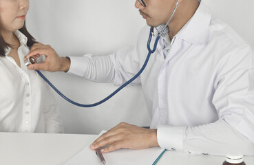 Doctor is checking heart wave with patient at clinic.