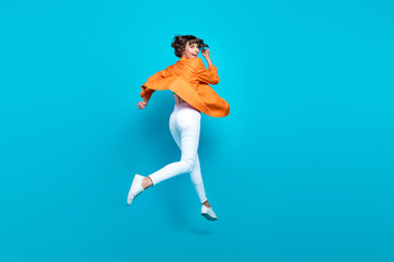 Fototapeta na wymiar Full size photo of cool young brunette lady run wear cardigan top jeans sneakers isolated on teal background