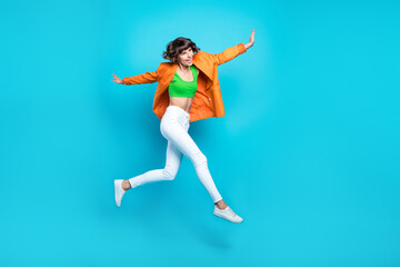 Fototapeta na wymiar Full size photo of cheerful happy young woman jump up enjoy good mood active isolated on blue color background