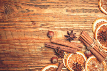 Dried orange slices, cinnamon and hazelnuts on a wooden background. View from above.