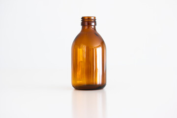 Empty brown glass medical bottle with no cap on. Close up studio shot, isolated on white background