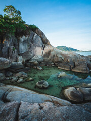 Scenic view of stunning rock formation cliff, rocky bay with hidden small lagoon, blue water against blue sky. Hin Ta Hin Yai, Lamai Beach, Koh Samui Island, Thailand.