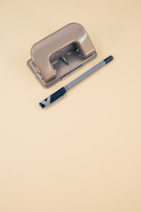 Closeup of a ballpoint pen and a hole puncher