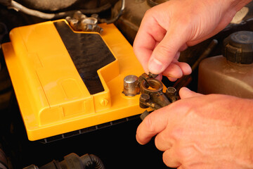 Car battery connecting cable terminal. An auto mechanic changes the battery in a car. An auto...