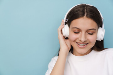 Young woman smiling while listening music with headphones