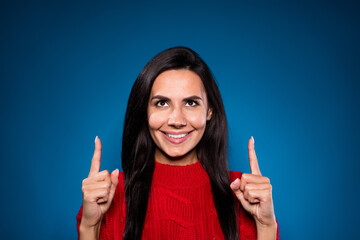 Photo of happy sweet attractive young woman point fingers up empty space isolated on gradient blue color background