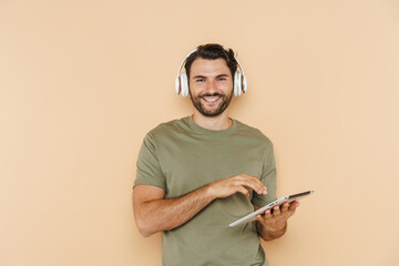 White bristle man using tablet computer and headphones
