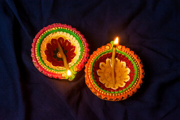 Happy Diwali - Colorful clay diya or oil lamps lit during Deepavali.