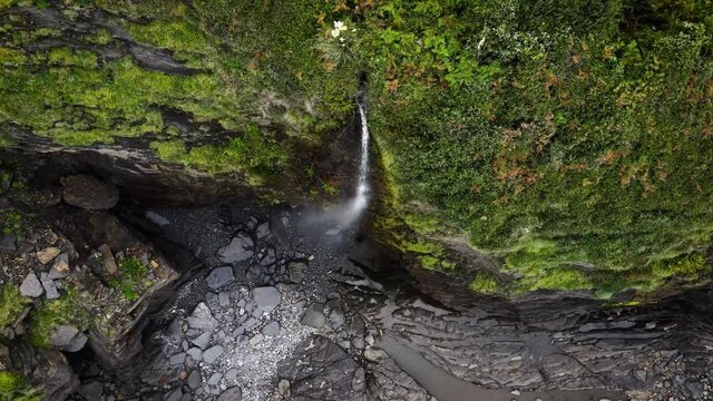 Waterfall spills down steep seacliffs on Basque Country coastline, Spain. High quality 4k footage